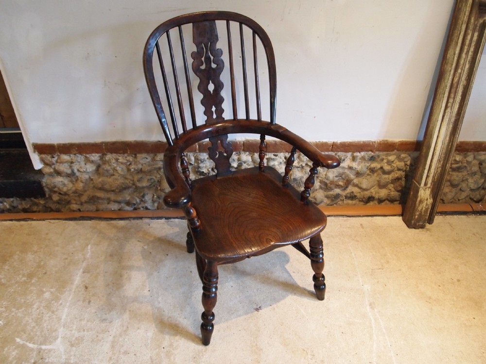 An antique 19th-century yew wood Windsor armchair featuring a bowed top rail, pierced central splat, turned spindles, armrests, and turned legs joined by an H-stretcher. View XI