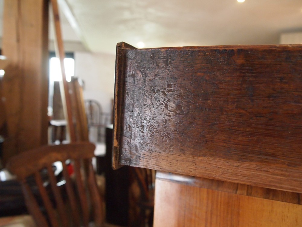 An 18th-century Welsh oak potboard dresser featuring an open plate rack, small upper drawers, a base with main drawers, shaped aprons, and turned legs. View IX