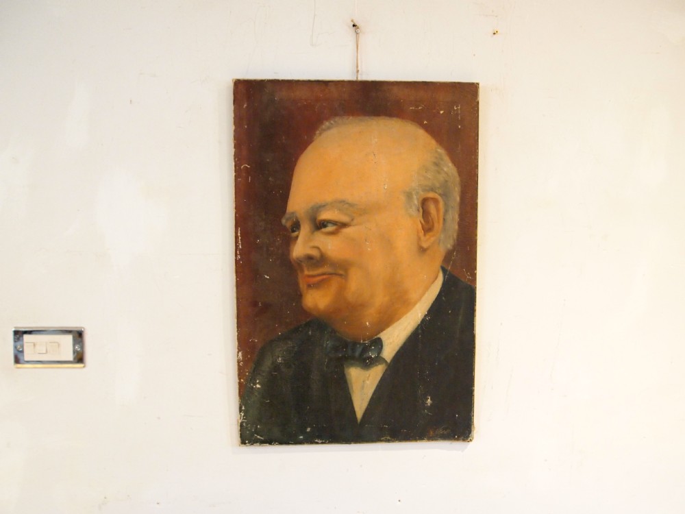 An unframed oil painting on canvas depicting a portrait of Sir Winston Churchill in profile against a dark brown background. View III