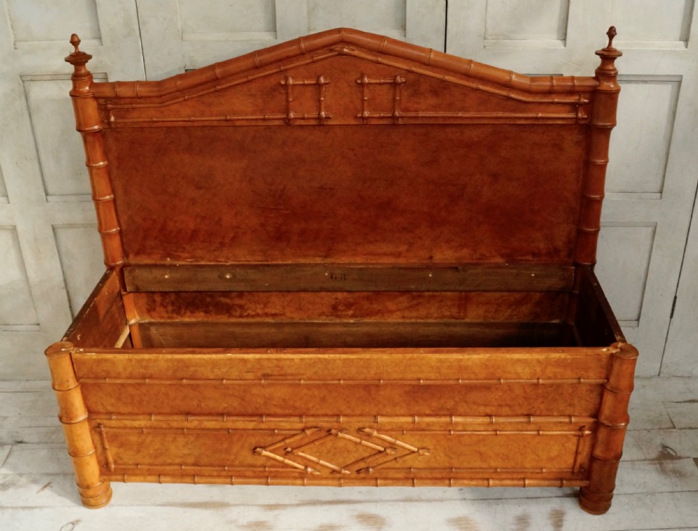 An antique faux bamboo hall bench featuring turned timber frame detailing, a shaped backrest with geometric cresting, and an off-white upholstered seat. View V