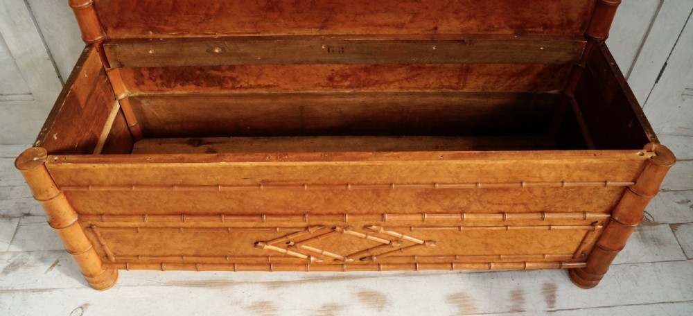 An antique faux bamboo hall bench featuring turned timber frame detailing, a shaped backrest with geometric cresting, and an off-white upholstered seat. View VI