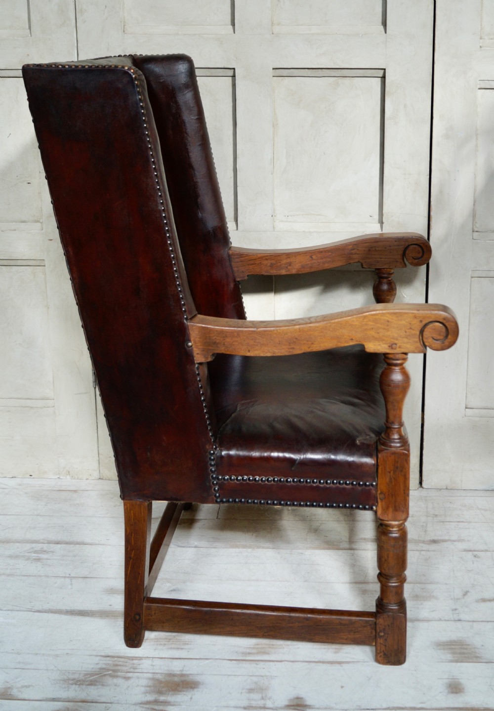 A Victorian library chair featuring dark brown aged leather upholstery with studding detail and a solid oak frame with turned front legs. View V