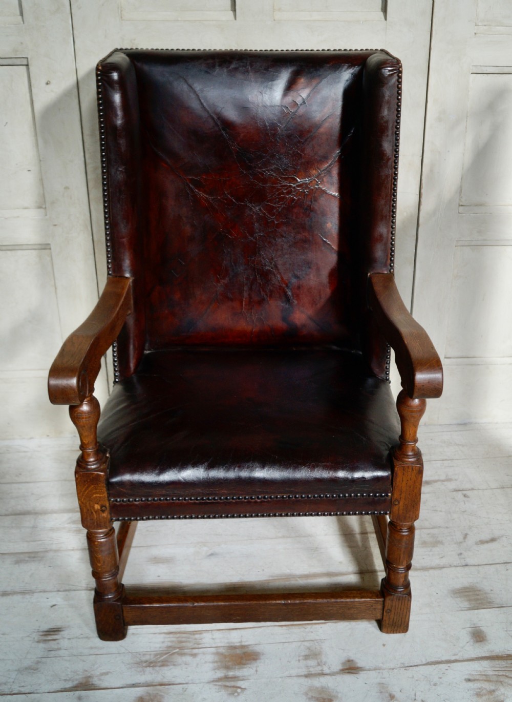 A Victorian library chair featuring dark brown aged leather upholstery with studding detail and a solid oak frame with turned front legs. View X