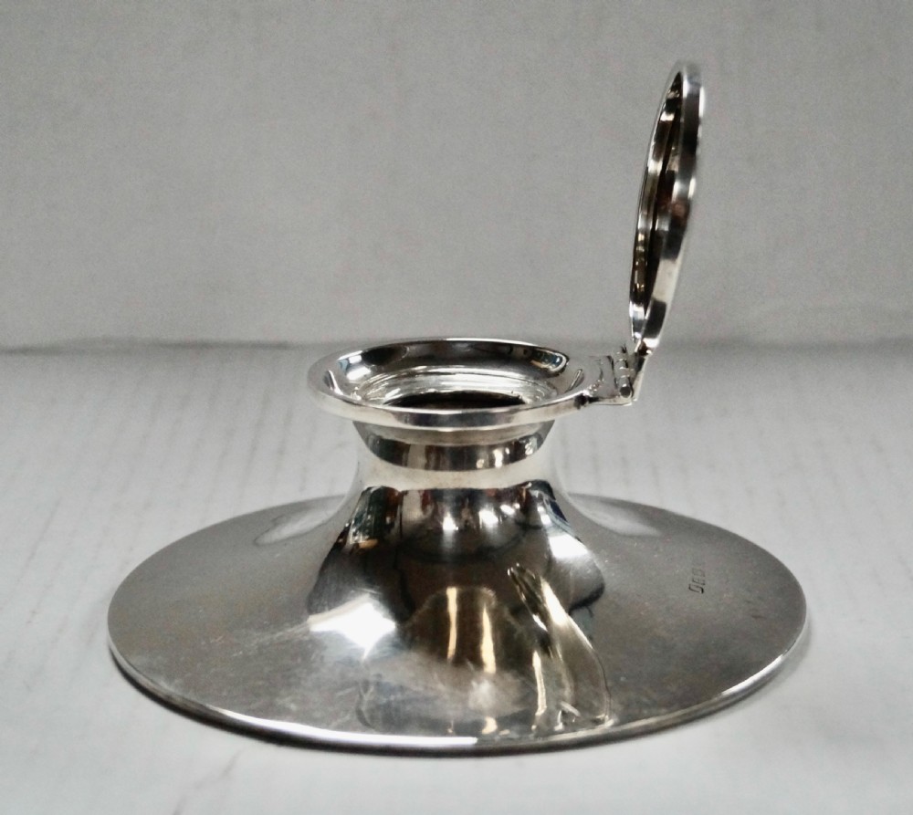 A solid sterling silver capstan inkwell with a circular flared base and an open hinged lid, displaying Birmingham hallmarks.