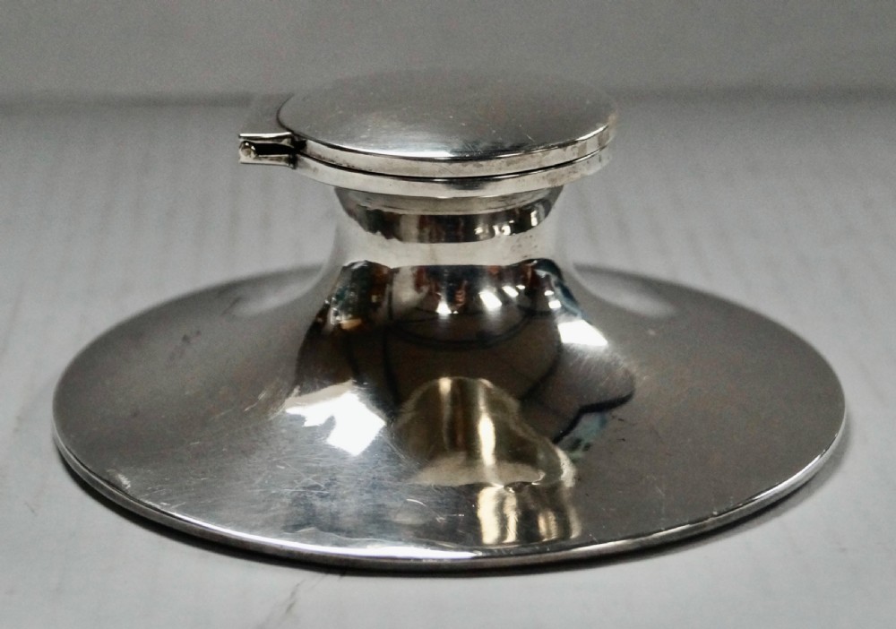 A solid sterling silver capstan inkwell with a circular flared base and an open hinged lid, displaying Birmingham hallmarks. View III