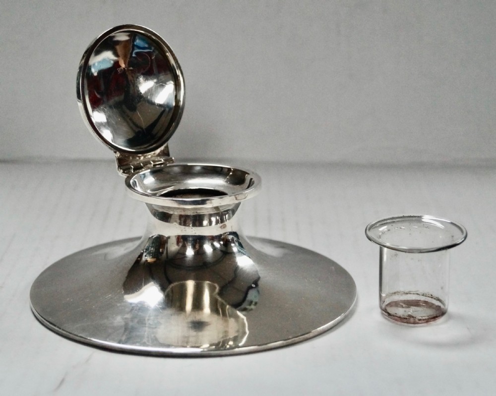 A solid sterling silver capstan inkwell with a circular flared base and an open hinged lid, displaying Birmingham hallmarks. View X