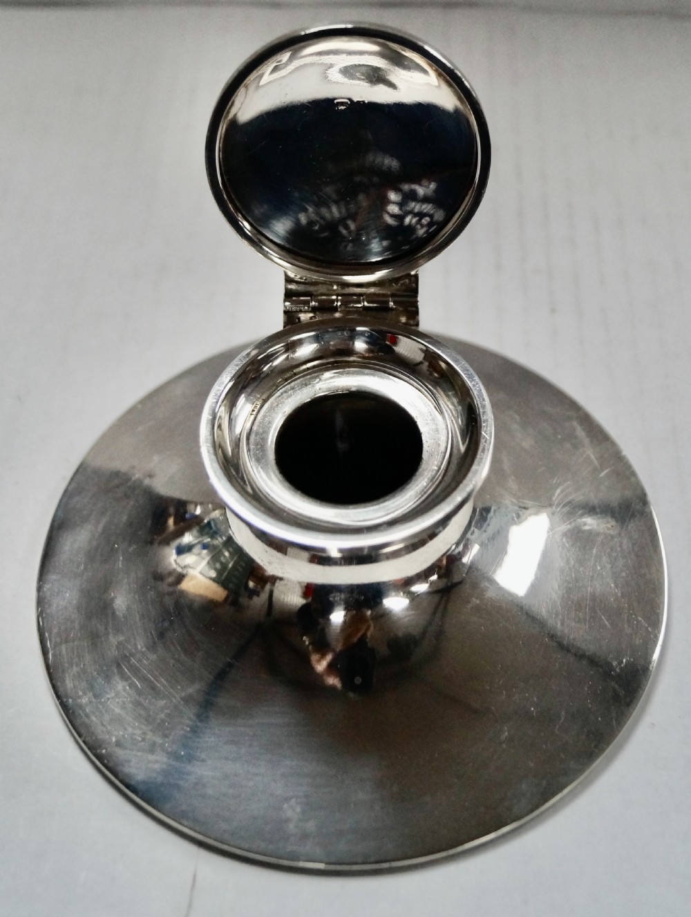A solid sterling silver capstan inkwell with a circular flared base and an open hinged lid, displaying Birmingham hallmarks. View XII