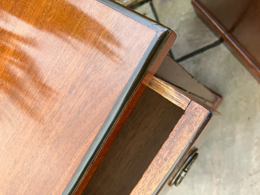 A pair of tall mahogany bedside chests featuring three drawers each with circular brass handles and a plinth base. View III