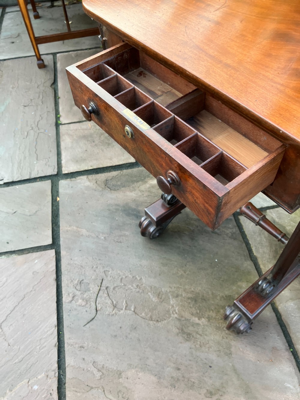 A William IV mahogany side table featuring a single drawer with turned knobs, resting on turned trestle supports and scroll feet. View II