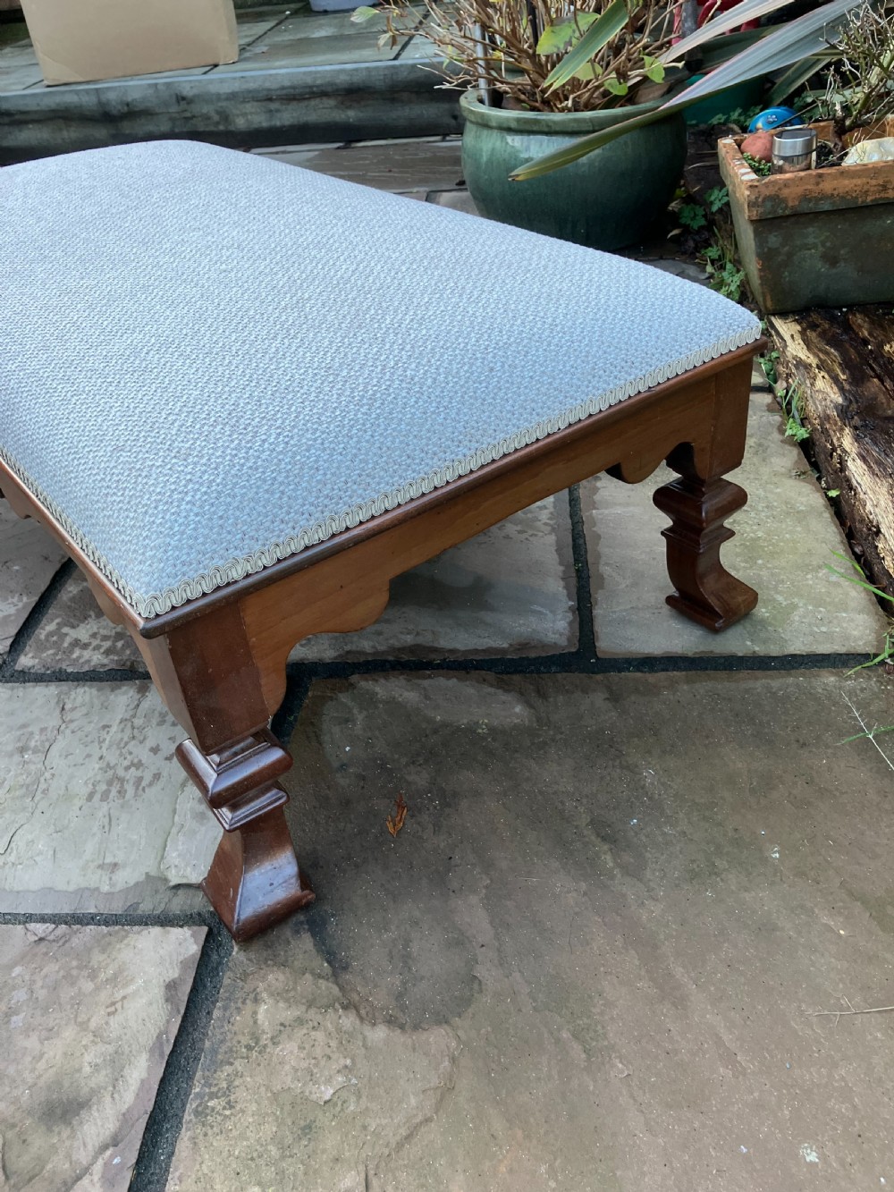 A low rectangular Victorian mahogany footstool upholstered in pale blue fabric with a shaped apron and turned legs. View III