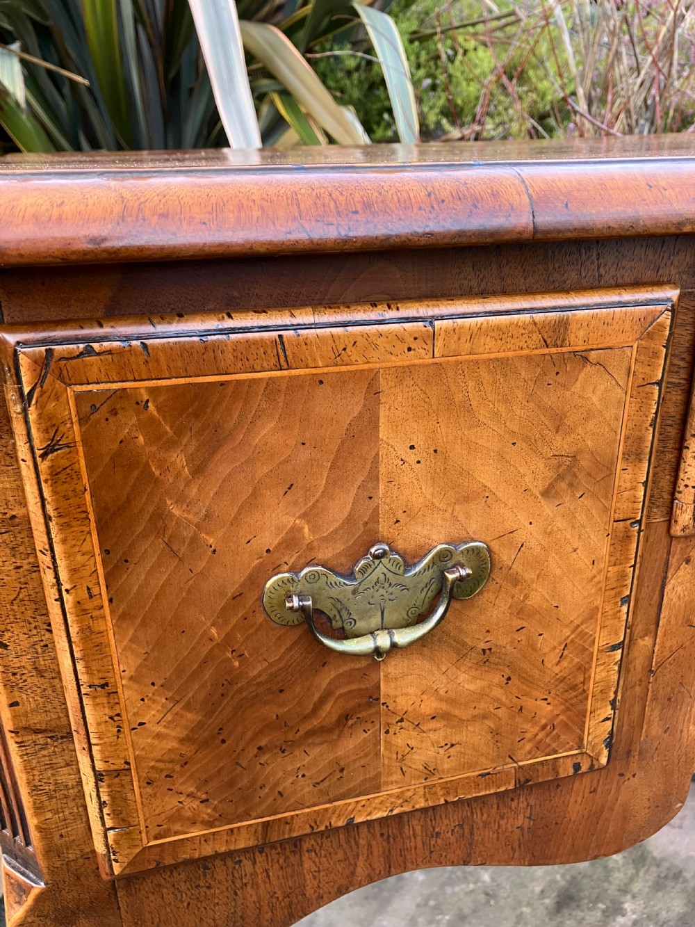 A Queen Anne style walnut lowboy featuring three drawers, brass drop handles, a shaped apron, and cabriole legs ending in ball and claw feet. View IV