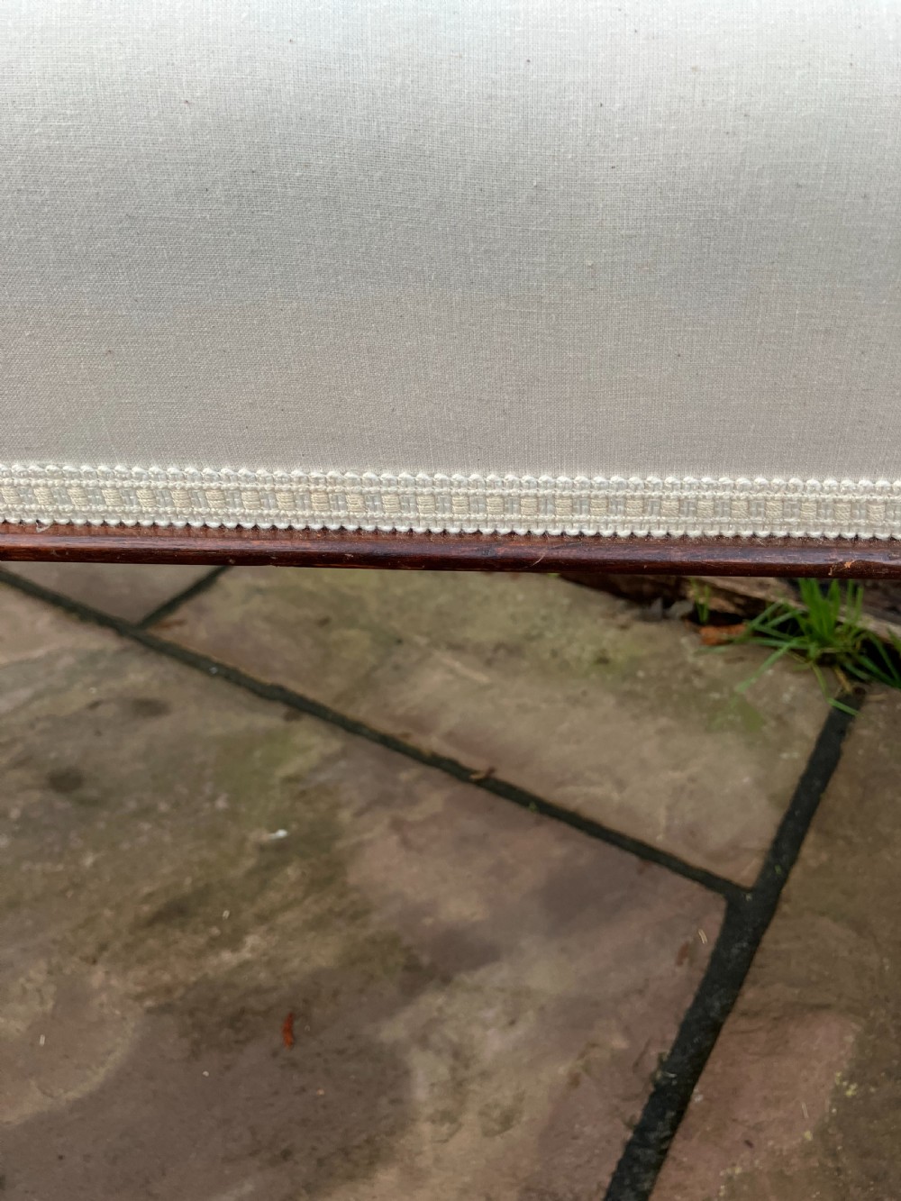 A long rectangular mahogany bench featuring cream leather upholstery supported by four reeded turned legs with brass castors. View III