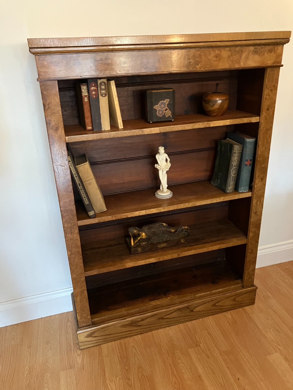 A Victorian pollard oak open bookcase featuring multiple fixed shelves, rich burl graining along the frame, and a wide plinth base.