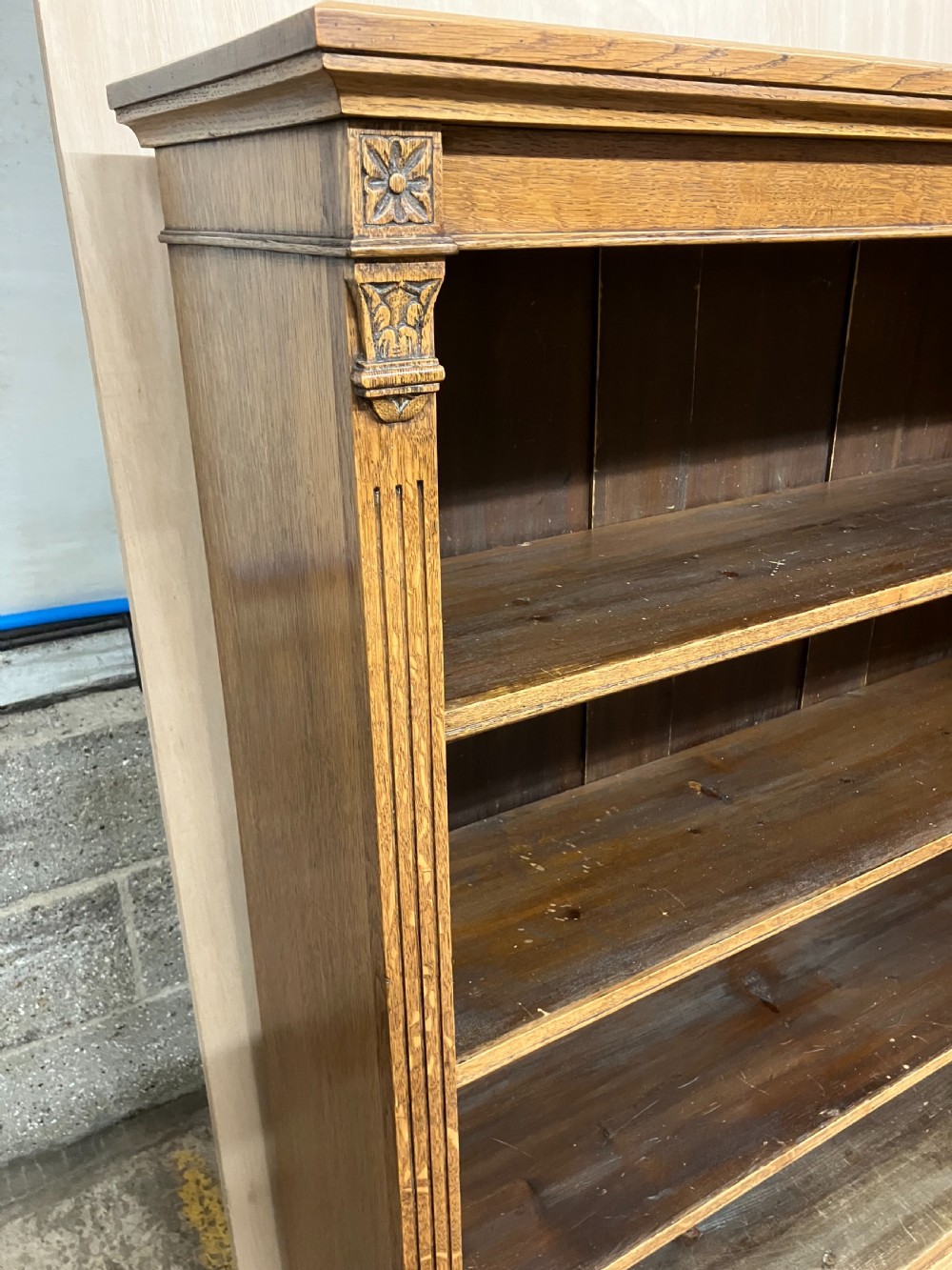 An antique Victorian oak open bookcase featuring four shelf levels, fluted pilasters, and carved corner rosettes. View II