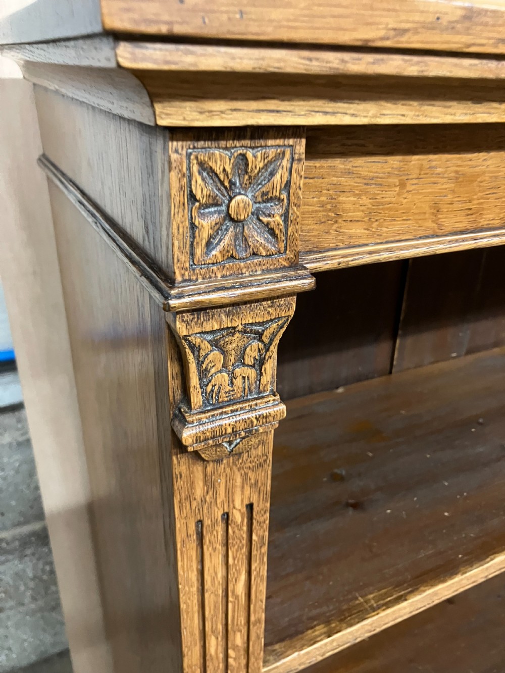 An antique Victorian oak open bookcase featuring four shelf levels, fluted pilasters, and carved corner rosettes. View III