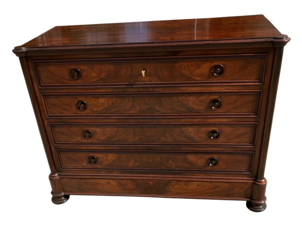 A French rosewood commode with four wide drawers, turned wooden knobs, and a dark polished grain finish.