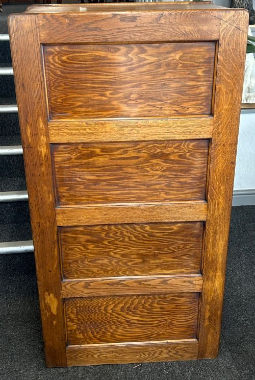 fig 1. A vertical four-drawer golden oak filing cabinet featuring brass label holders and metal pull handles.