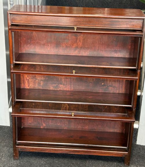 fig 1. A three-tier mahogany barrister bookcase featuring glazed front doors and small circular brass knobs.