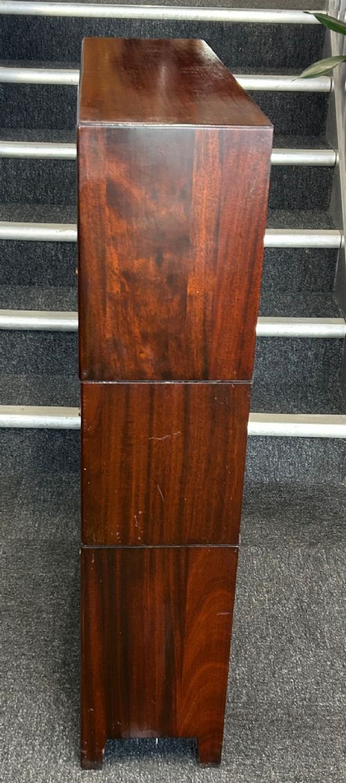 A three-tier mahogany barrister bookcase featuring glazed front doors and small circular brass knobs. View IV