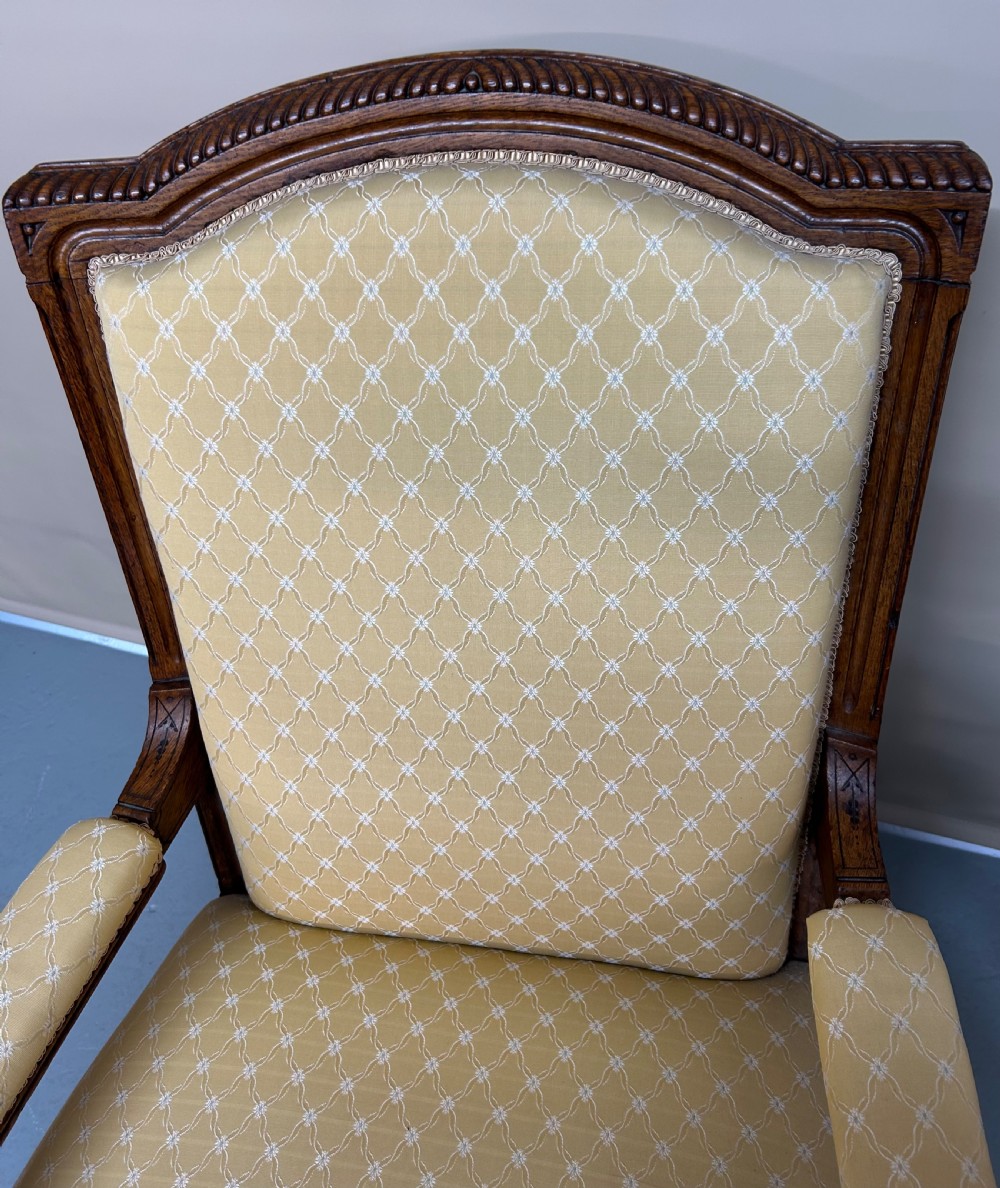 A pair of Victorian pollard oak armchairs upholstered in yellow patterned fabric featuring reeded turned legs and brass castors. View IV