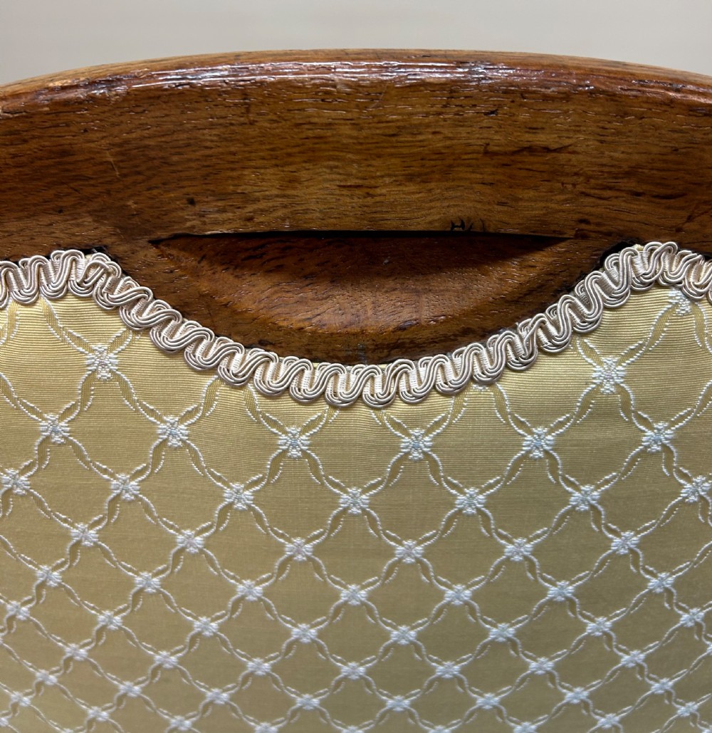 A pair of Victorian pollard oak armchairs upholstered in yellow patterned fabric featuring reeded turned legs and brass castors. View IX
