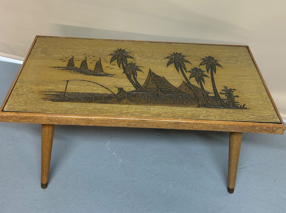 A light wood living room set featuring a low glass-top coffee table, standard lamp, table lamp base, and magazine rack, all decorated with pyrographic tropical scene carvings. View II