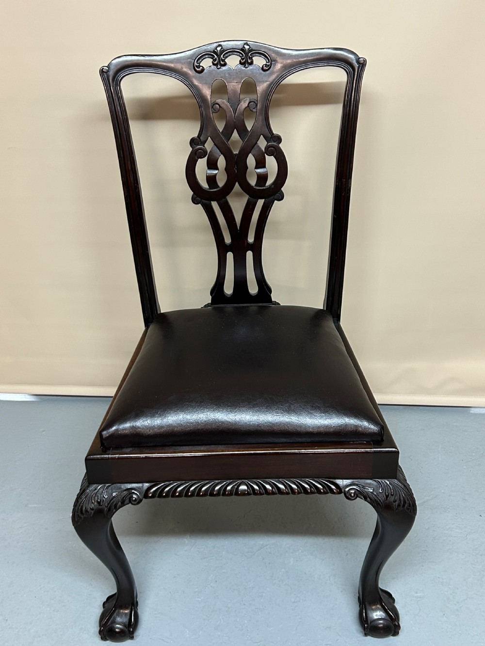 A set of six dark mahogany Chippendale style dining chairs featuring carved pierced back splats, dark leather seats, and front cabriole legs with ball and claw feet. View II