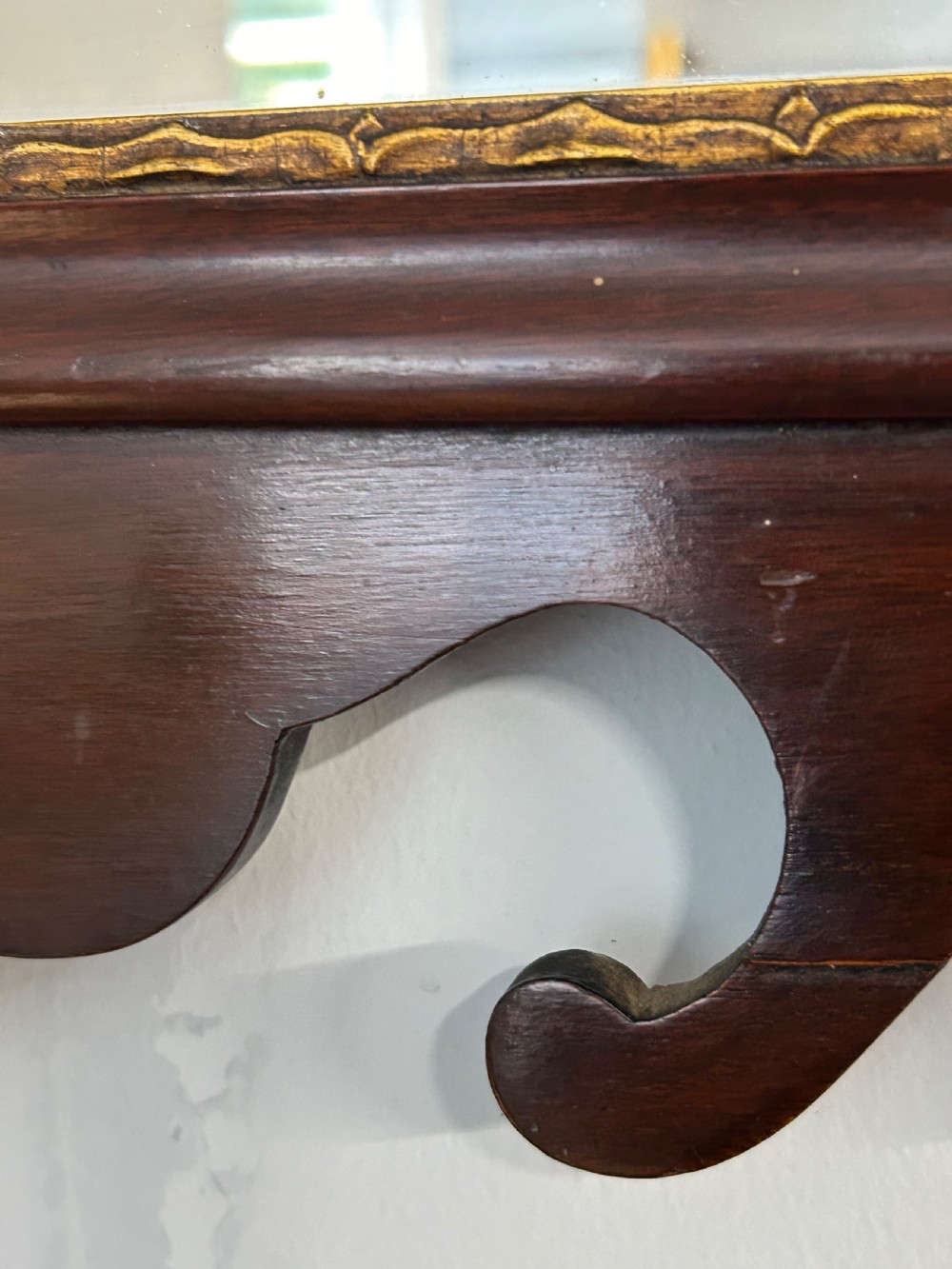 A rectangular Georgian style mahogany wall mirror featuring a scroll-cut fretwork frame topped with a gilded bird crest. View IV