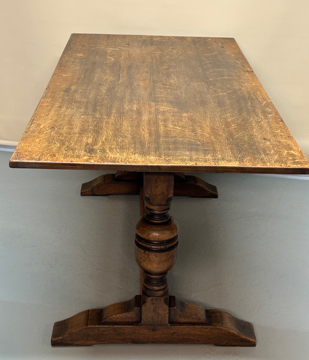 A solid oak refectory dining table featuring a rectangular top, heavy turned baluster legs, and a low central stretcher. View II