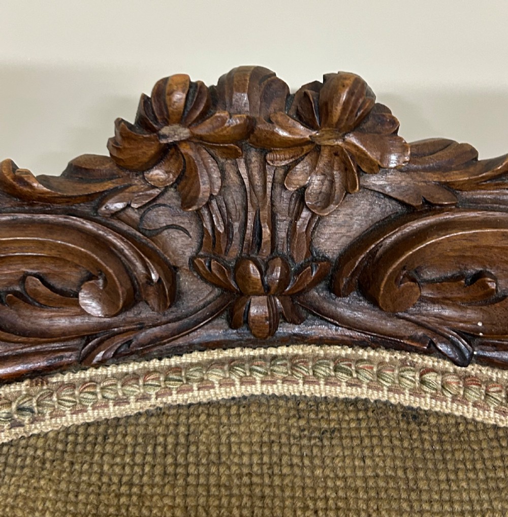 A Victorian carved walnut nursing chair with floral needlepoint tapestry upholstery and cabriole legs. View IV