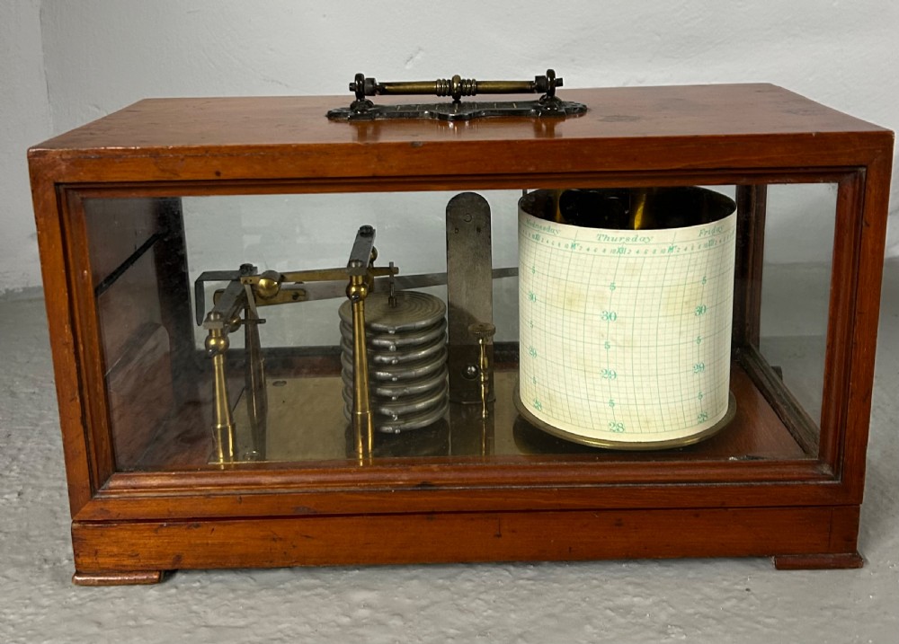 An antique oak and glass barograph featuring a revolving chart drum, internal brass mechanism, thermometer scale, and a brass carrying handle on top. View IV
