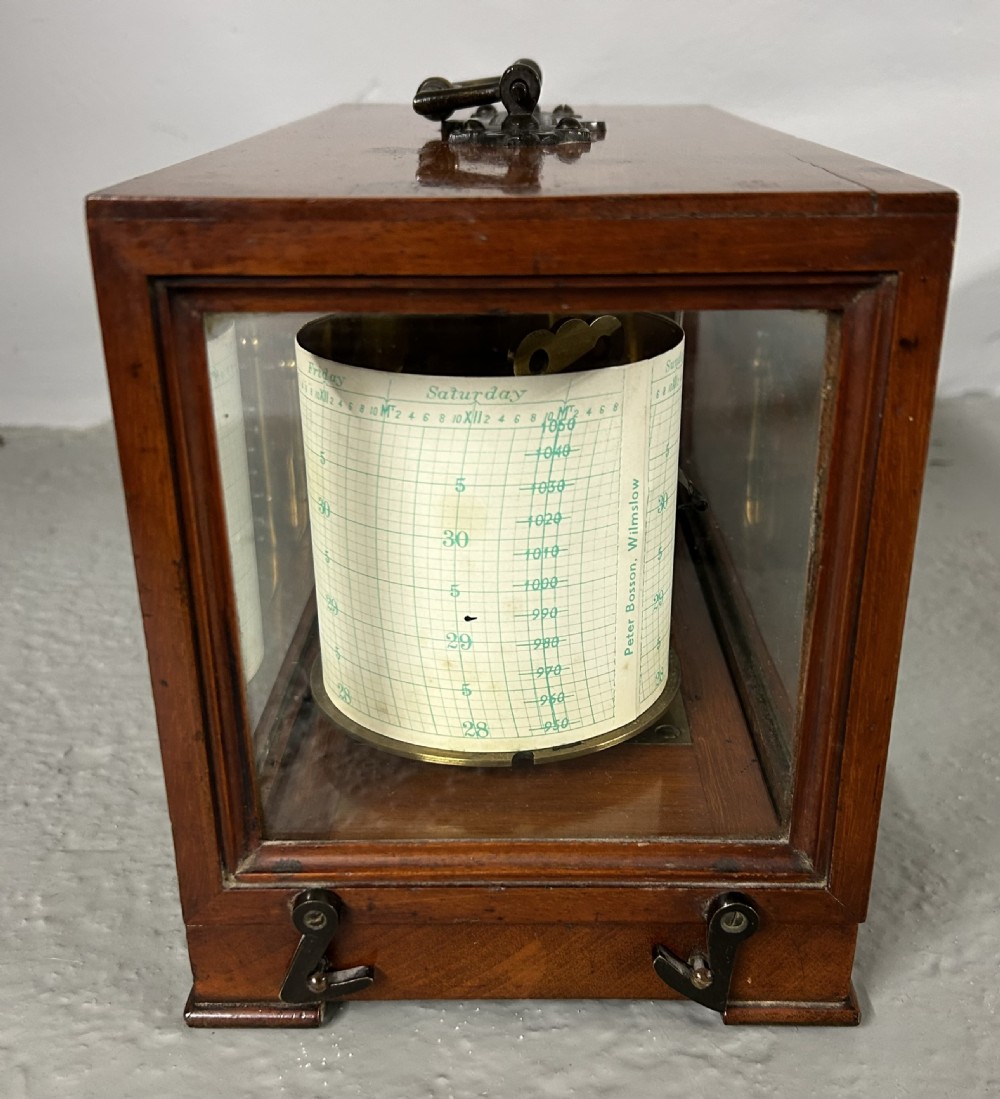 An antique oak and glass barograph featuring a revolving chart drum, internal brass mechanism, thermometer scale, and a brass carrying handle on top. View V