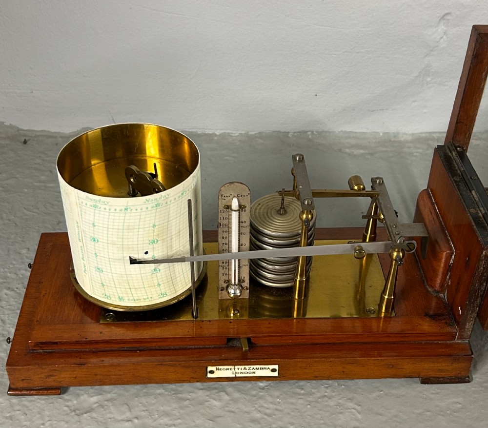 An antique oak and glass barograph featuring a revolving chart drum, internal brass mechanism, thermometer scale, and a brass carrying handle on top. View IX