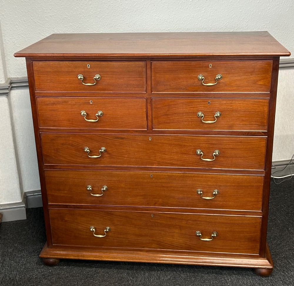 A nineteenth-century solid walnut chest of drawers featuring four short drawers over three long drawers with brass swan-neck handles and escutcheons.