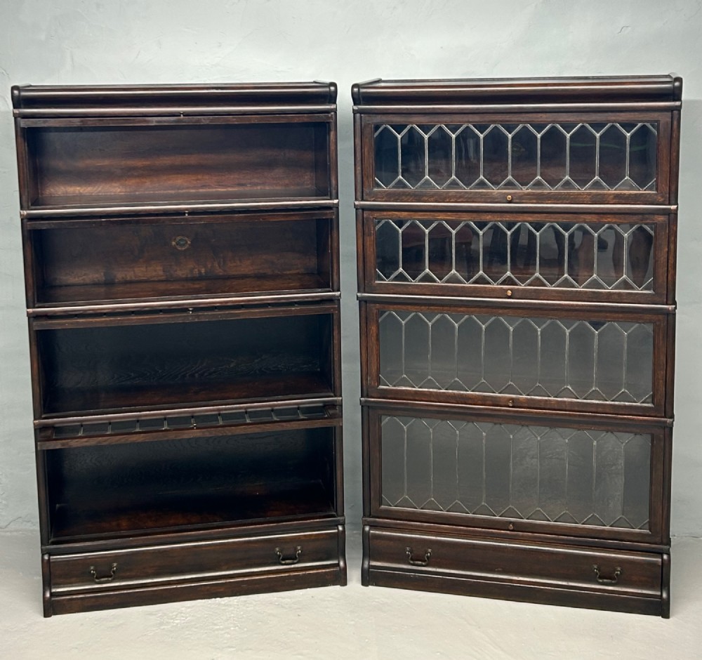 A pair of dark oak Globe Wernicke sectional bookcases featuring four leaded glass door compartments and a base drawer each. View III