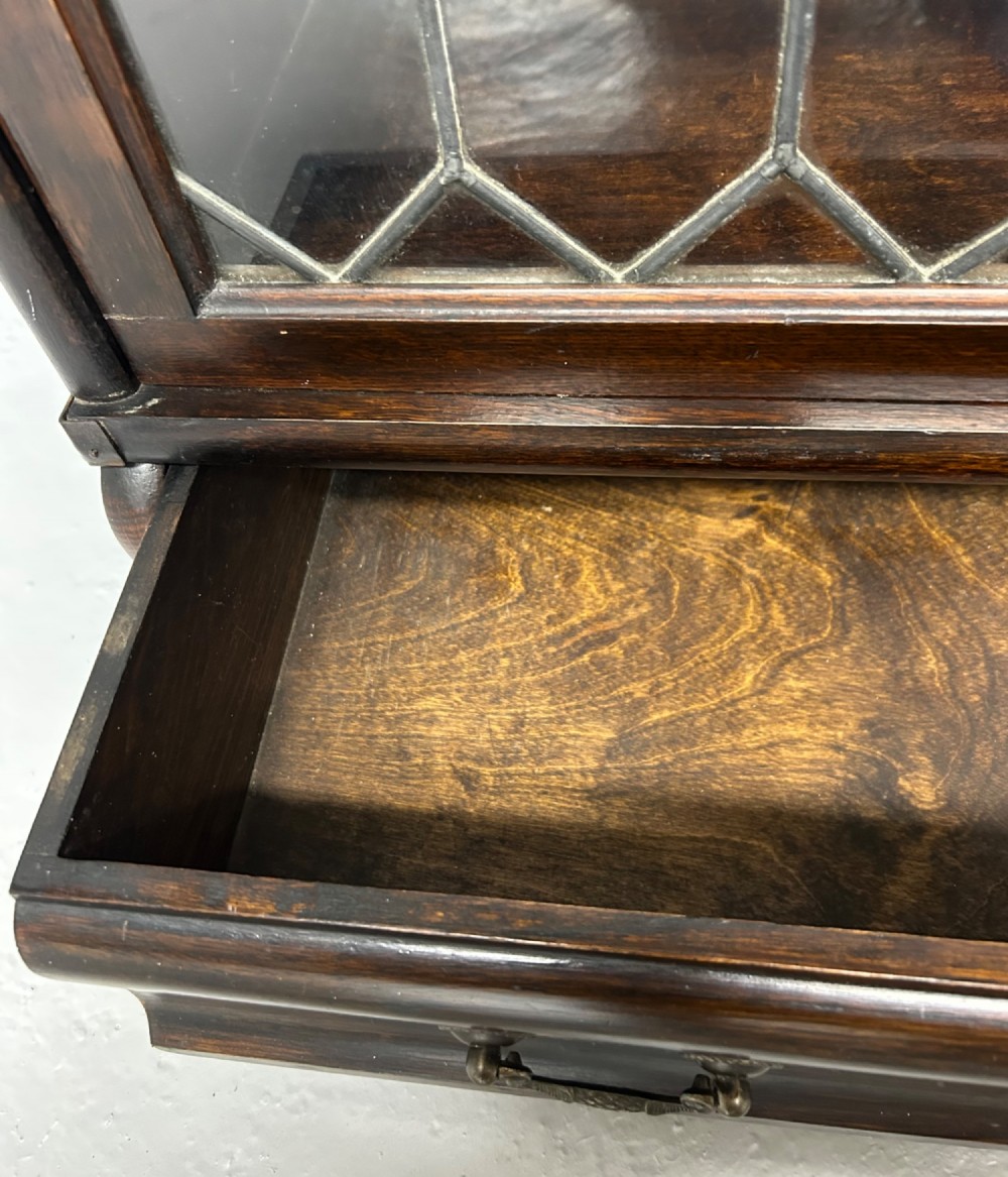 A pair of dark oak Globe Wernicke sectional bookcases featuring four leaded glass door compartments and a base drawer each. View VIII