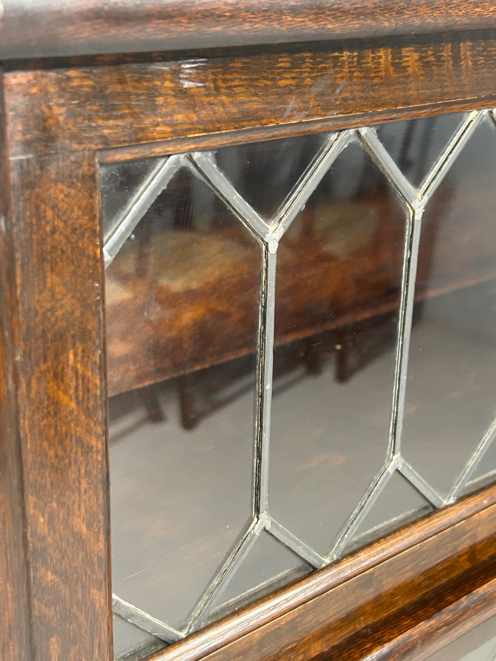 A pair of dark oak Globe Wernicke sectional bookcases featuring four leaded glass door compartments and a base drawer each. View IX