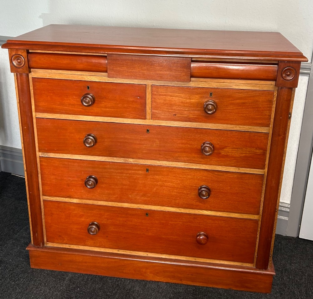 A Victorian mahogany and oak chest of drawers featuring two short drawers over three long drawers with turned wooden knobs and roundel details. View II