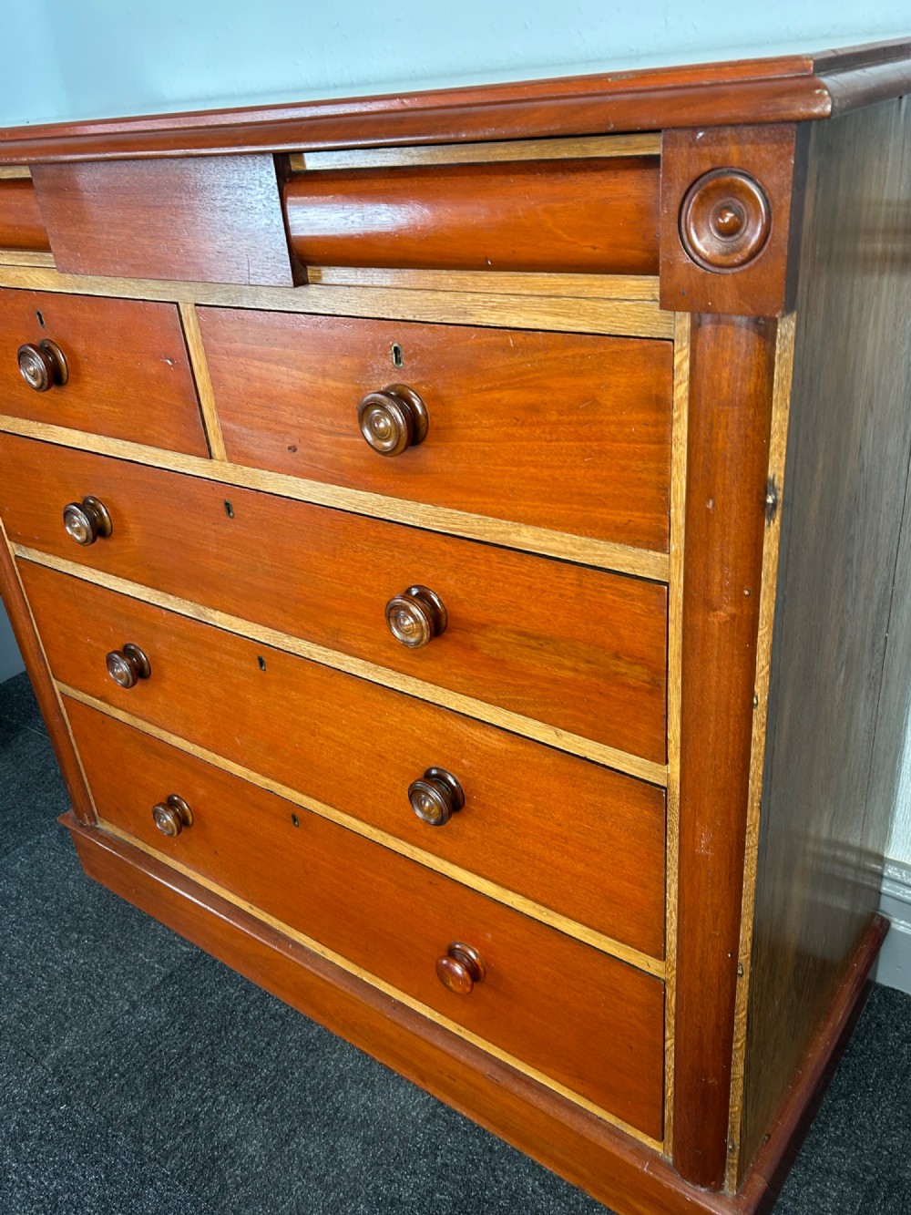 A Victorian mahogany and oak chest of drawers featuring two short drawers over three long drawers with turned wooden knobs and roundel details. View III