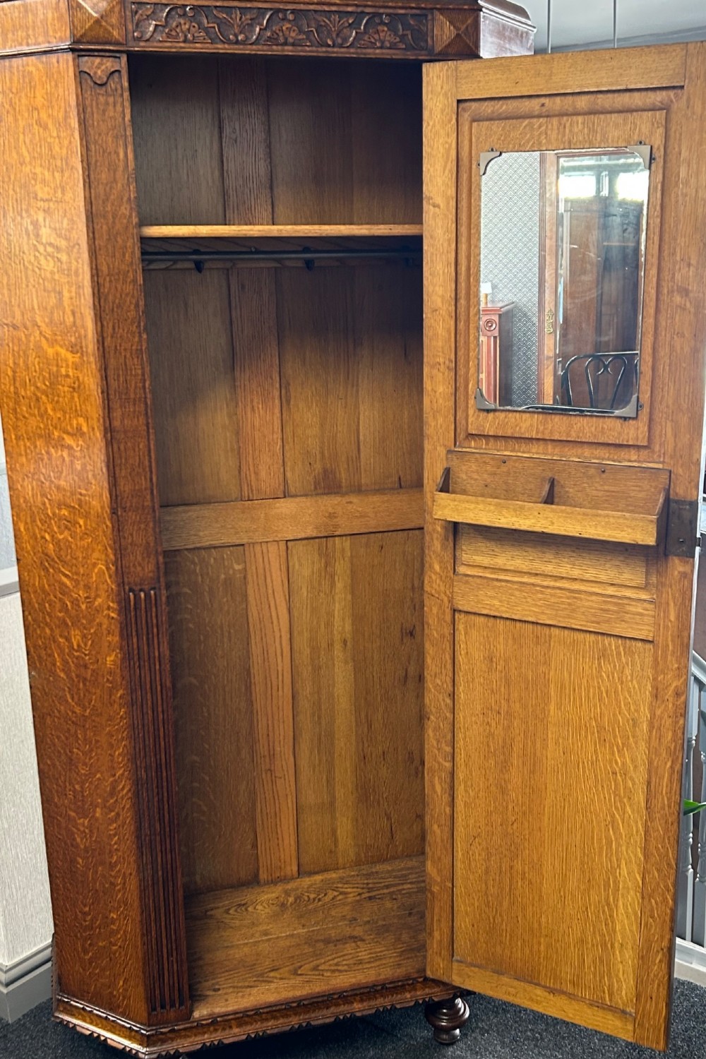 A tall 1920s solid oak hall robe featuring a single door with carved arcading and linenfold panelling, canted sides, and turned feet. View VI