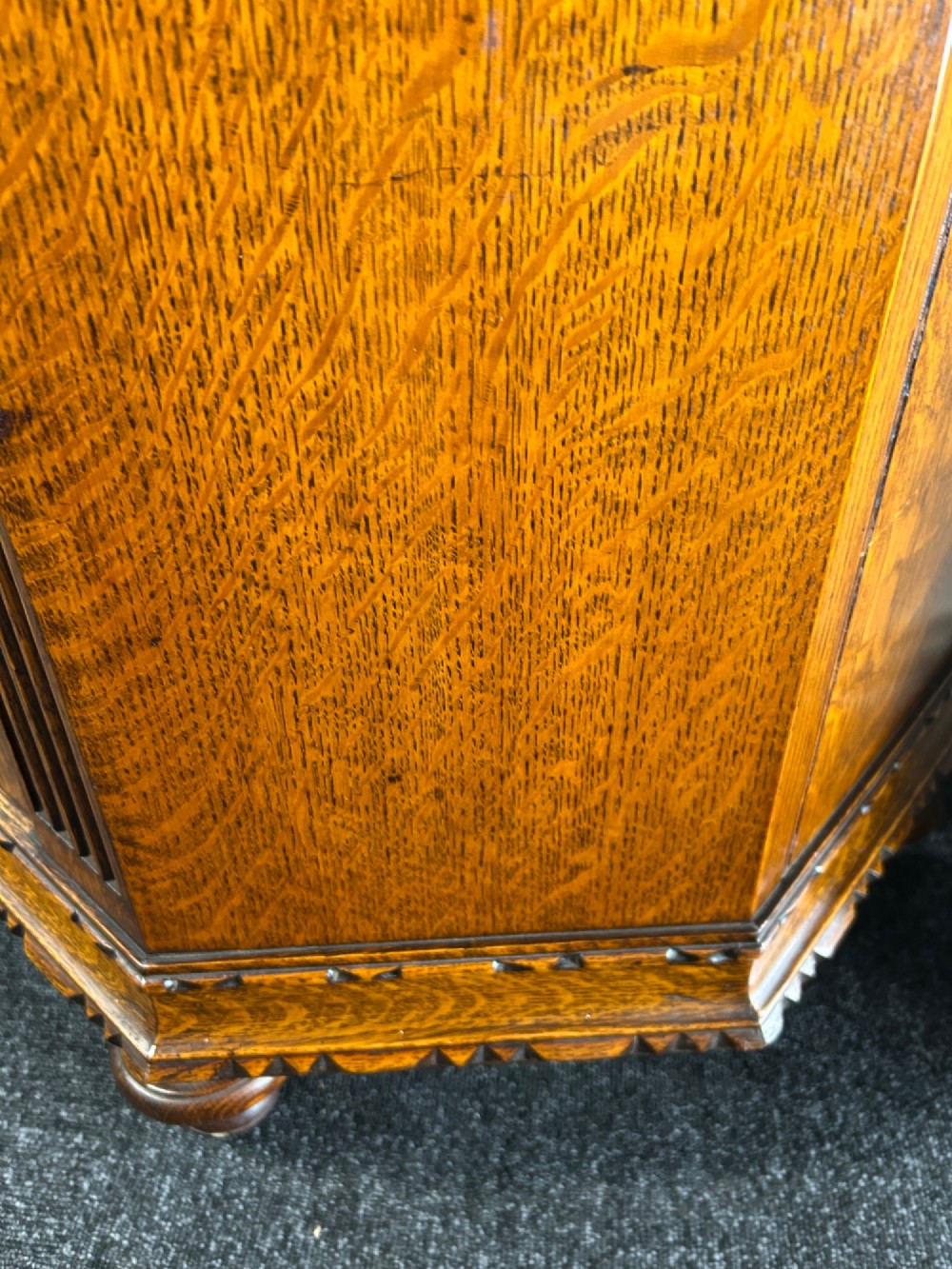 A tall 1920s solid oak hall robe featuring a single door with carved arcading and linenfold panelling, canted sides, and turned feet. View VII
