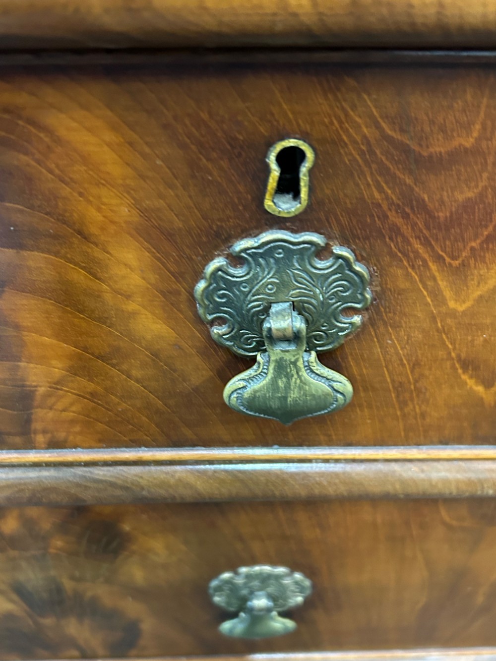 A nineteenth-century Victorian flame mahogany chest of drawers featuring two short drawers over three long graduated drawers with decorative brass drop handles and bun feet. View III