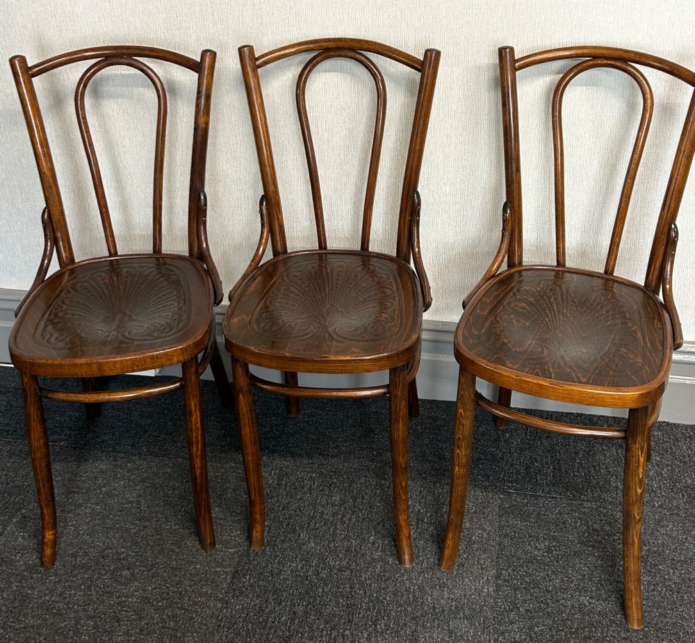 A set of six dark brown bentwood dining chairs featuring curved backrests and relief patterned wooden seats. View II