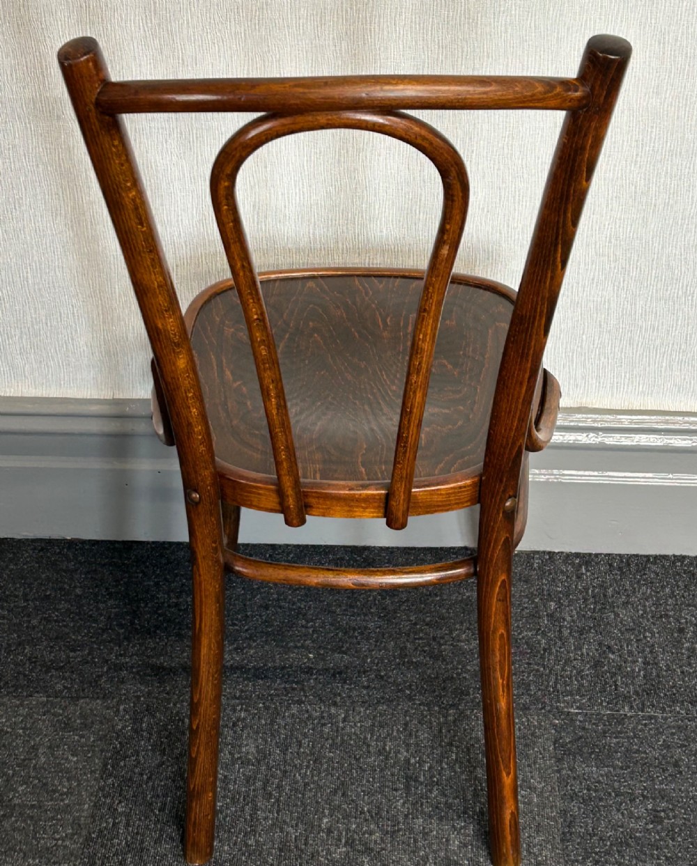 A set of six dark brown bentwood dining chairs featuring curved backrests and relief patterned wooden seats. View IV