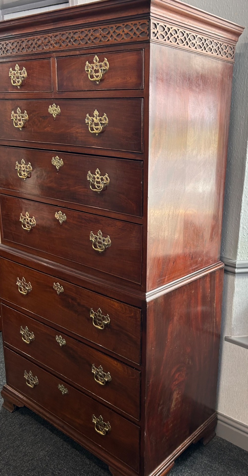 A tall Georgian mahogany chest on chest featuring eight drawers with brass swan-neck handles, blind fretwork frieze, and bracket feet. View III