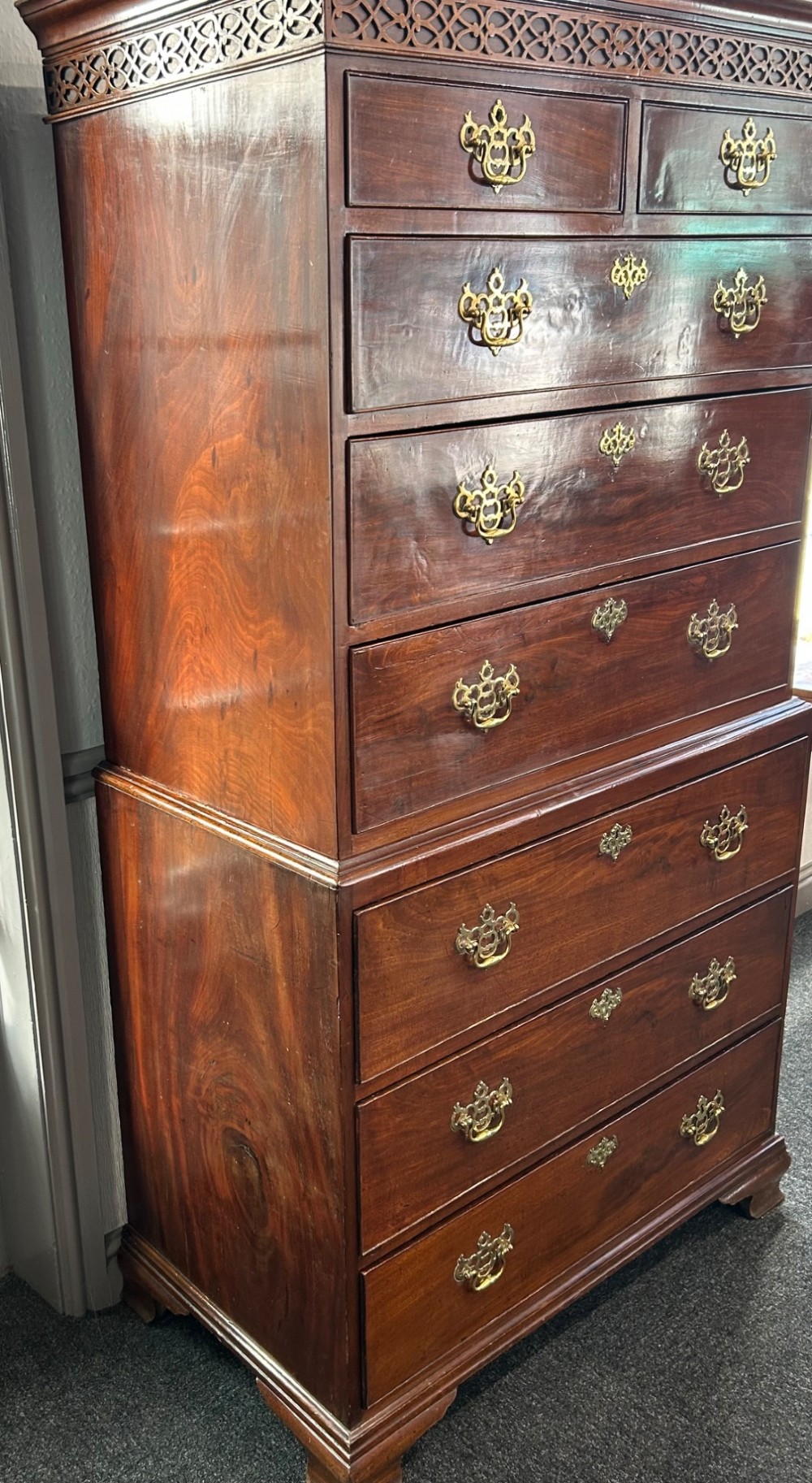 A tall Georgian mahogany chest on chest featuring eight drawers with brass swan-neck handles, blind fretwork frieze, and bracket feet. View IV