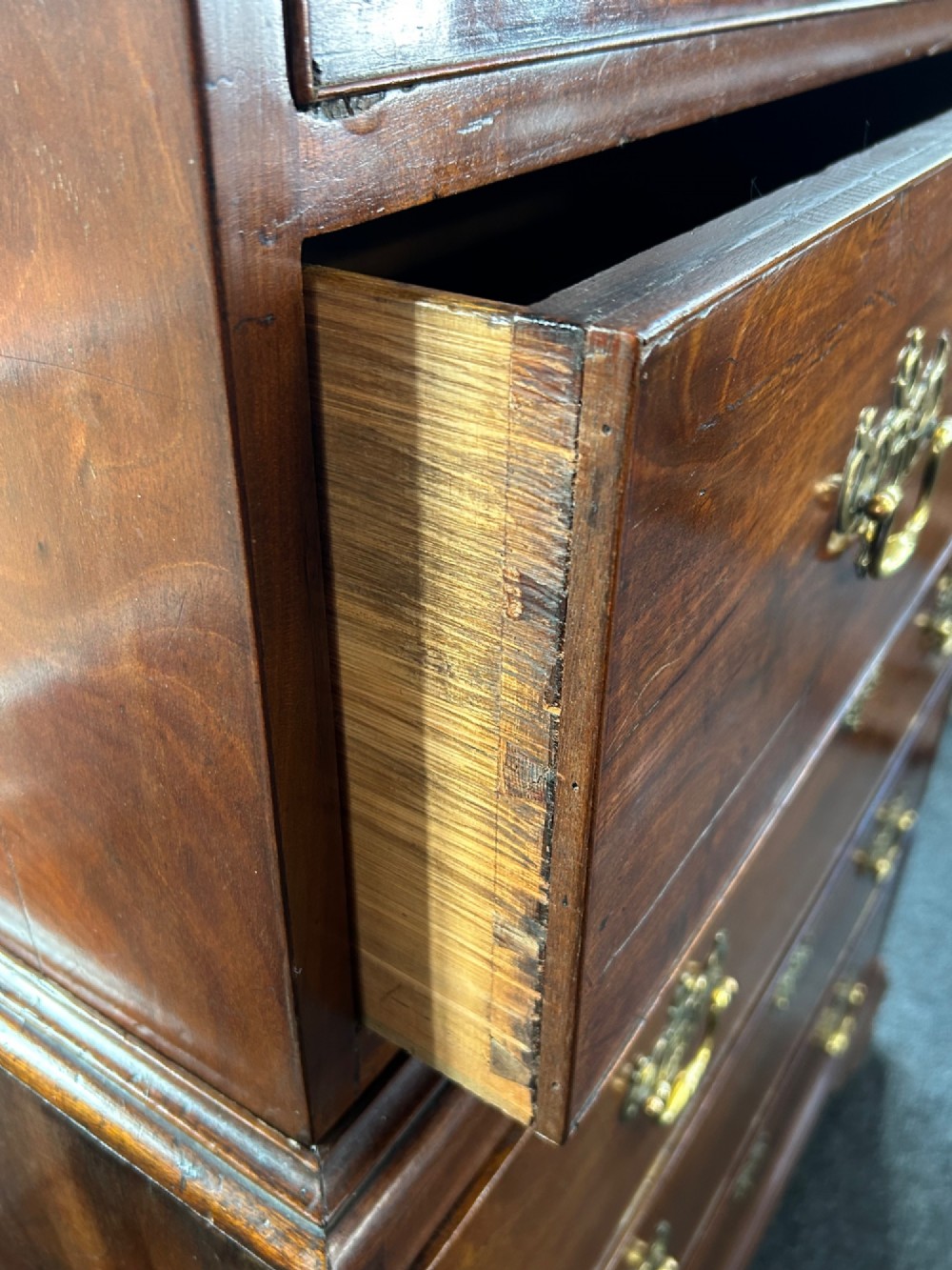 A tall Georgian mahogany chest on chest featuring eight drawers with brass swan-neck handles, blind fretwork frieze, and bracket feet. View VI