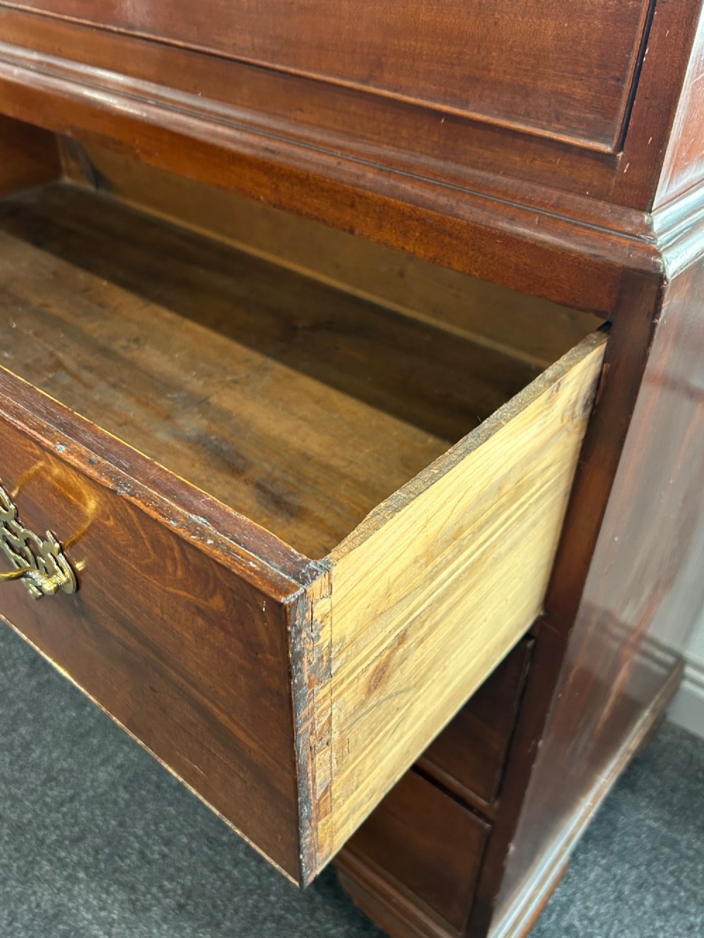 A tall Georgian mahogany chest on chest featuring eight drawers with brass swan-neck handles, blind fretwork frieze, and bracket feet. View VII