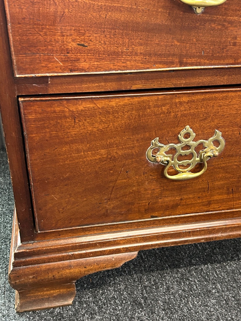 A tall Georgian mahogany chest on chest featuring eight drawers with brass swan-neck handles, blind fretwork frieze, and bracket feet. View IX