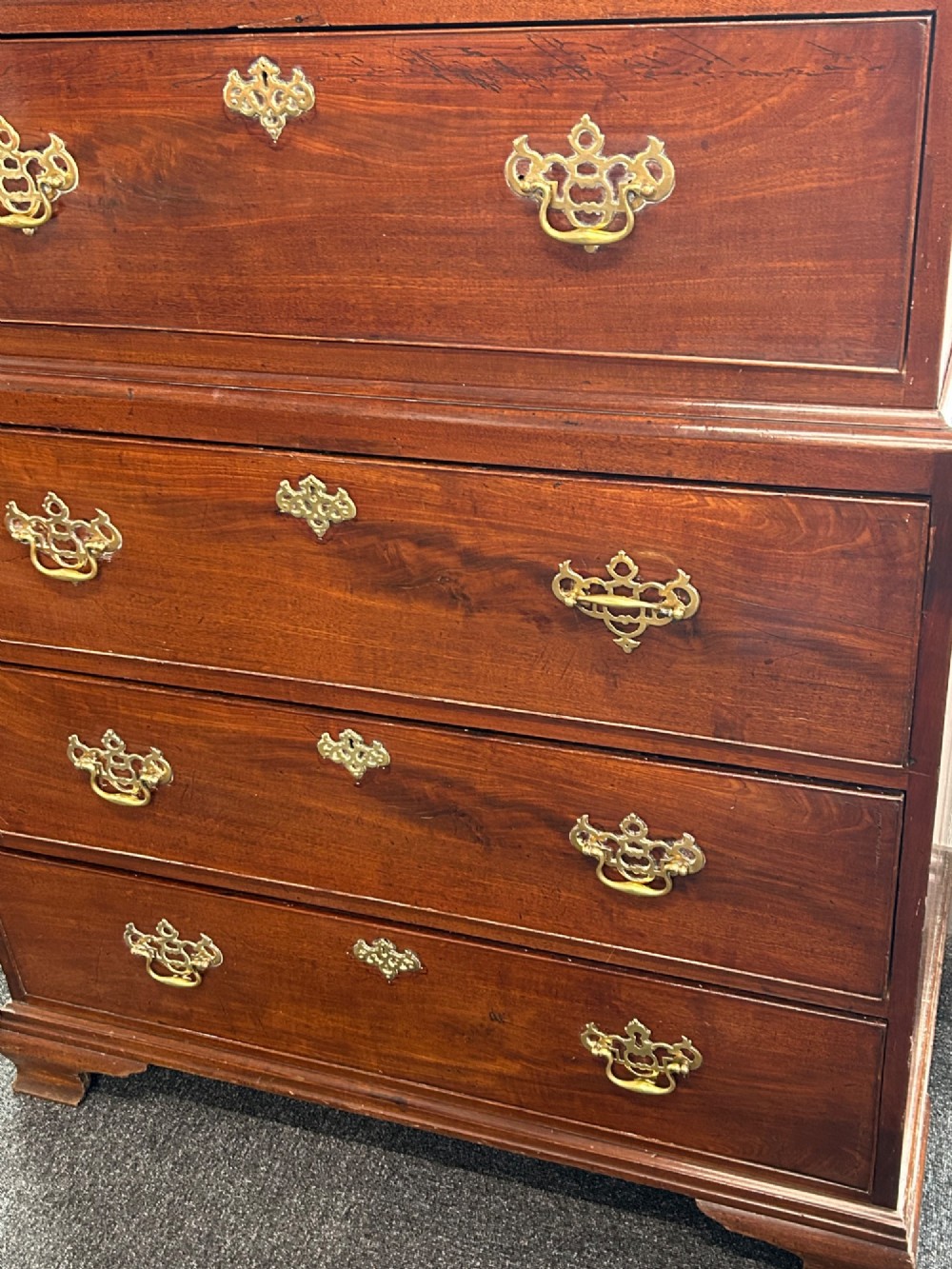 A tall Georgian mahogany chest on chest featuring eight drawers with brass swan-neck handles, blind fretwork frieze, and bracket feet. View X